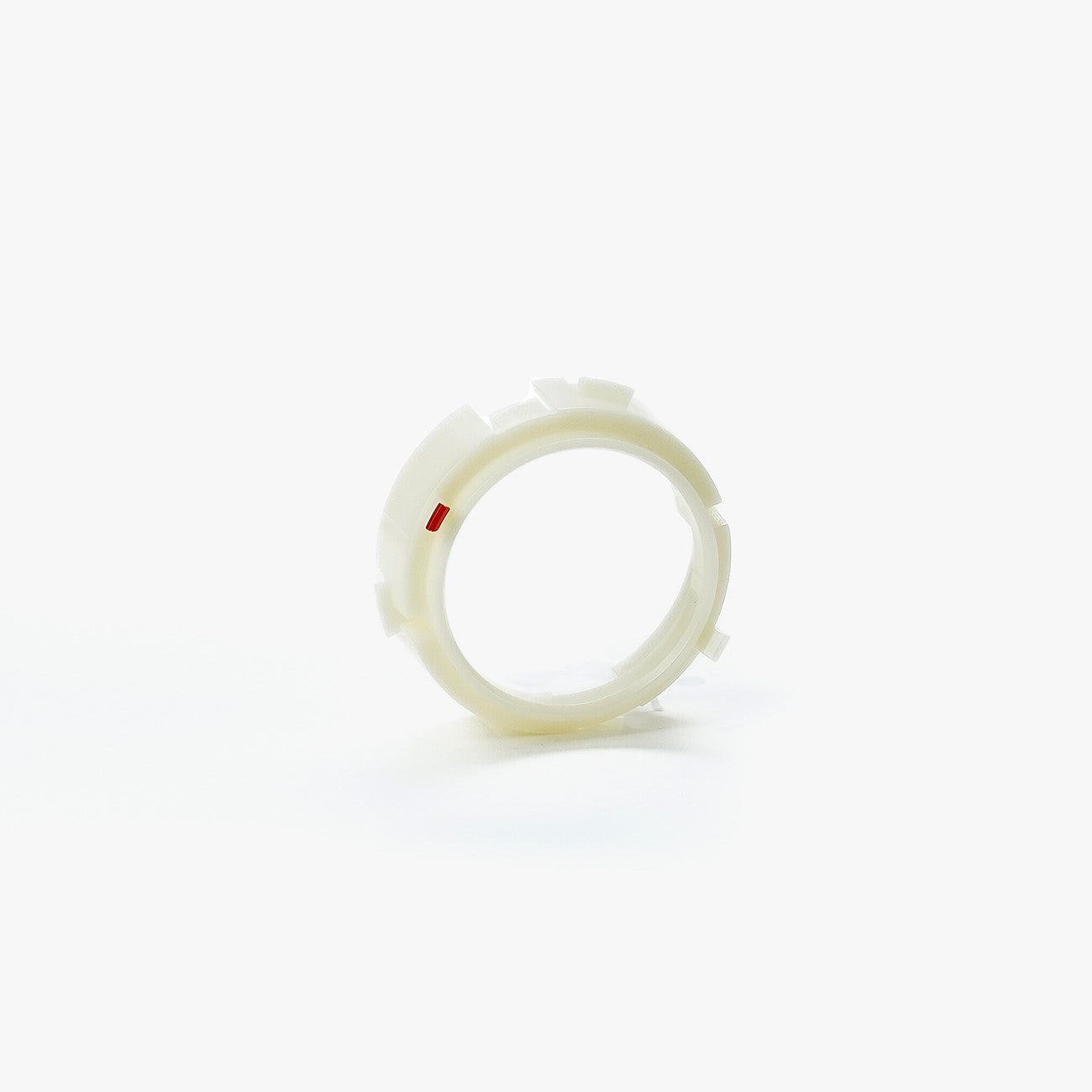 White plastic ring with a small red dot on a white background