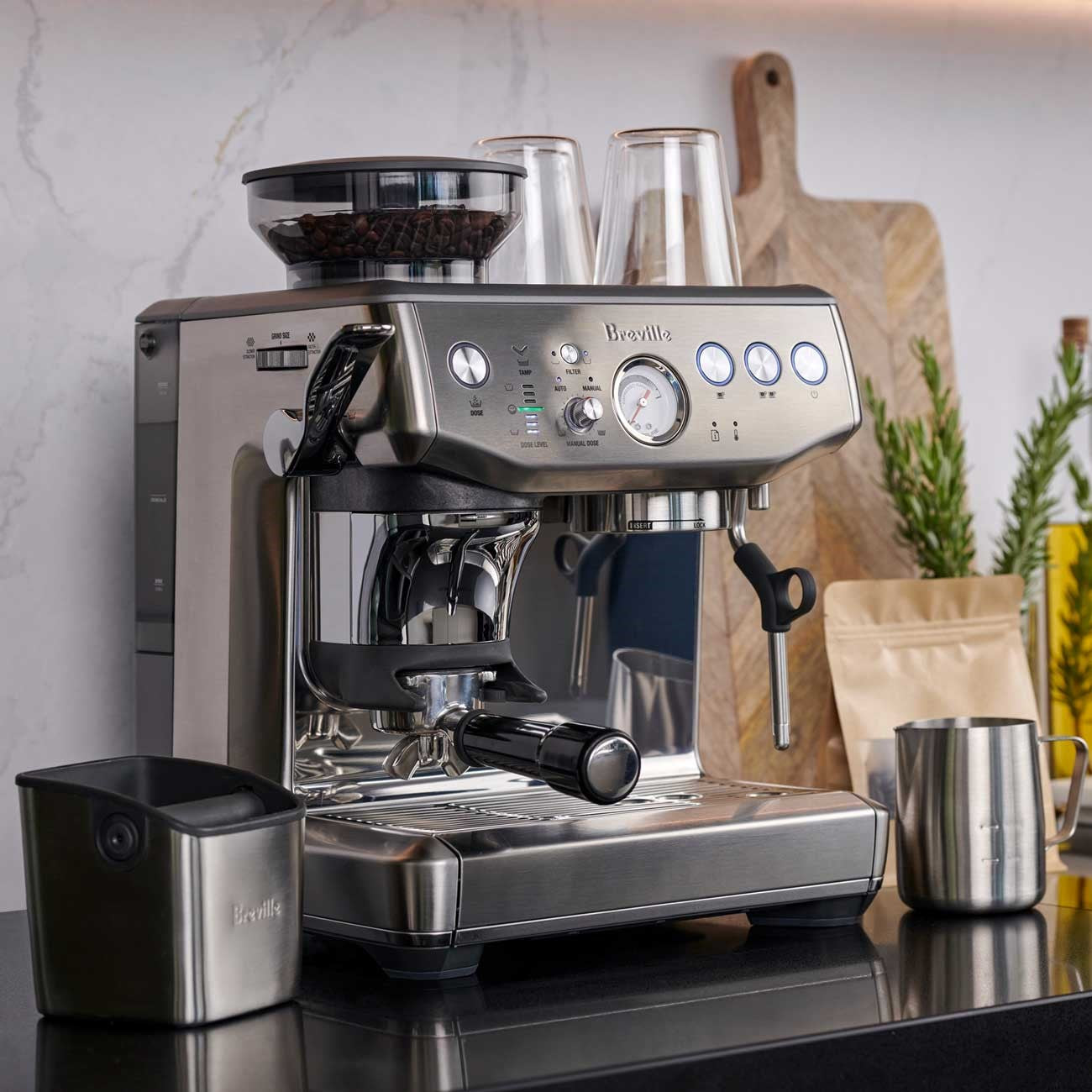 Barista Express Impress Kitchen Close Breville espresso machine on a kitchen counter with coffee accessories.