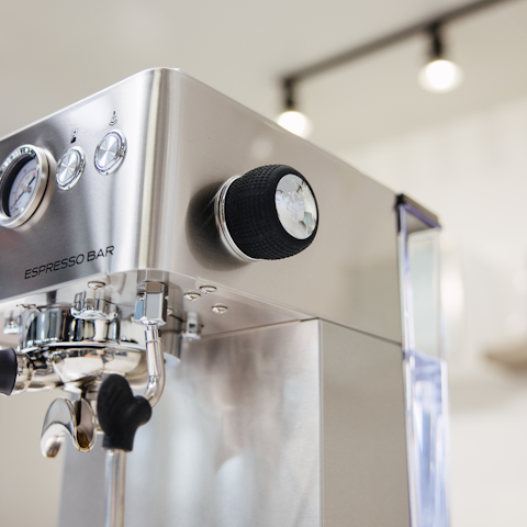Close-up of a stainless steel Bellucci espresso machine with visible branding.
