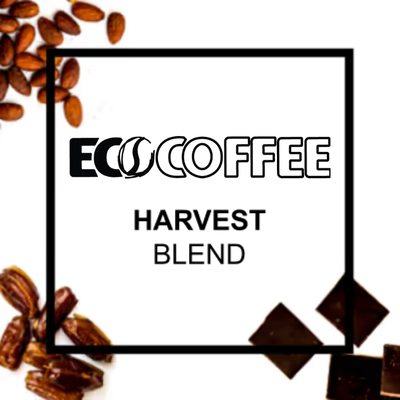 A square graphic with the text 'ECO COFFEE HARVEST BLEND' centered on a white background, surrounded by scattered coffee beans, pecans, and chocolate pieces. The ECO COFFEE logo is prominently displayed at the top of the frame.