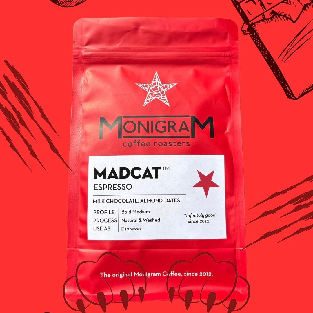 Monigram coffee roasters Madcat Espresso package on a red background with illustrations of almonds and chocolate.