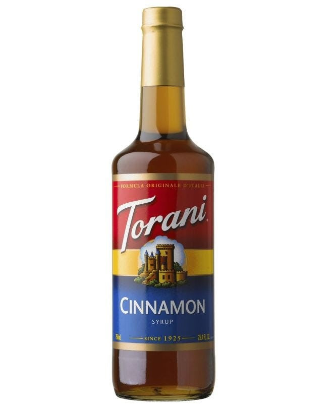 A bottle of Torani Cinnamon Syrup with a label featuring the brand name and a cityscape illustration.
