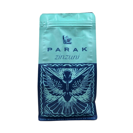 A stand-up pouch of Parak Zinzuni whole bean coffee on a plain white background. The packaging features a light turquoise top half with the brand name 'PARAK' and product name 'zinzuni' in dark blue, and a dark blue lower half decorated with a detailed bird illustration.
