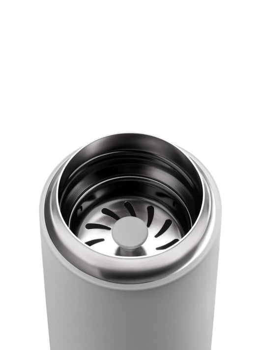 Close-up of a grey travel mug with a silver interior and metal splash guard on a white background