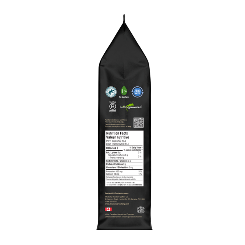 A tall black stand-up pouch of coffee shown from the back, featuring certification logos, a nutrition facts panel, and a QR code on a plain white background.