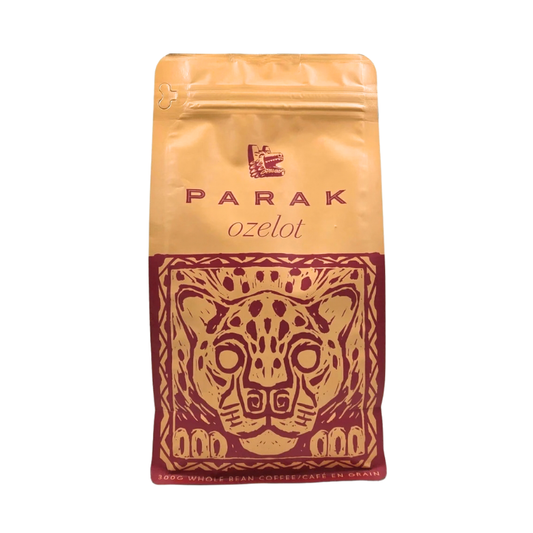 A stand-up pouch of Parak Ozelot coffee beans, featuring a gold and dark red design with a stylized jaguar head illustration.