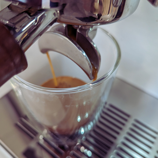 A shot of espresso being brewed