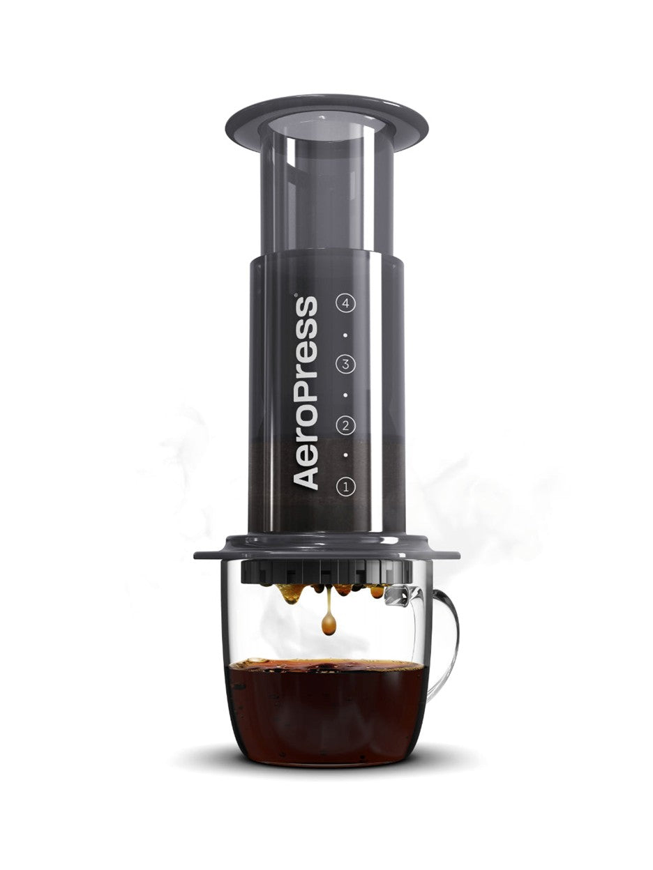 Aeropress coffee maker with a cup of coffee on a white background