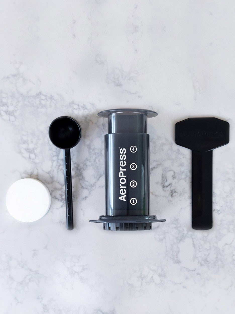 Aeropress coffee maker components on a marble surface