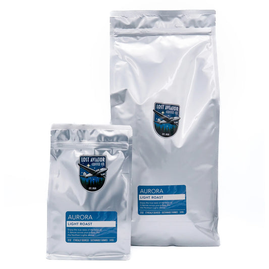 Two silver foil bags Aurora Light Roast coffee, one 340g and one 5lb, displayed on a clean white background.