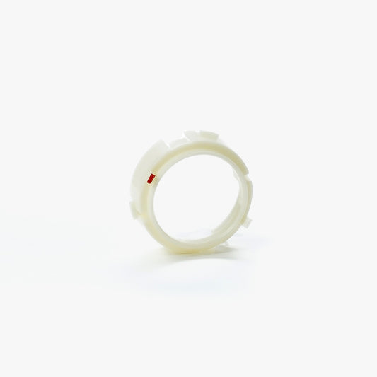 White plastic ring with a small red dot on a white background