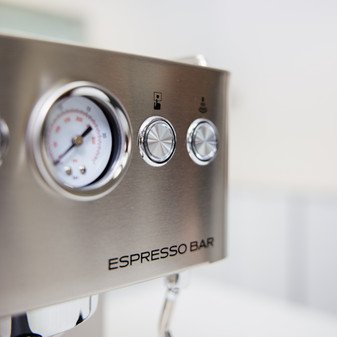 Metallic espresso machine control panel with gauges and 'Espresso Bar' branding.