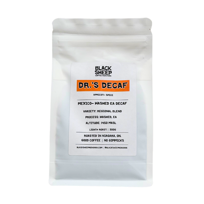 A white stand-up pouch of Black Sheep Coffee Roasters Dr.'s Decaf Espresso, featuring a white label with an orange accent bar and black text, set against a plain white background.