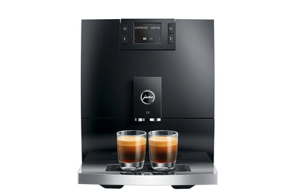 Black coffee machine with two glasses of espresso on a white background
