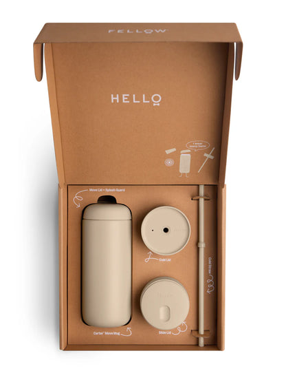A FELLOW travel mug set in a brown cardboard gift box, featuring a beige insulated bottle, a matching lid, a straw, and a cap, photographed on a white background.