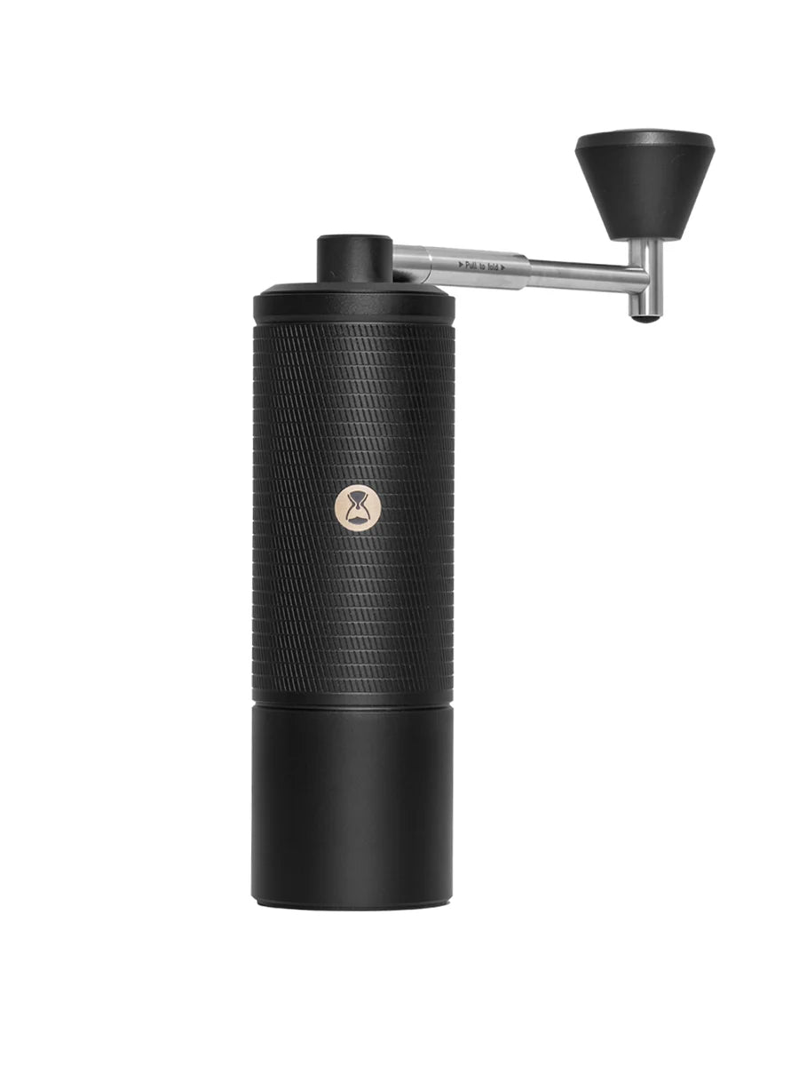 Black manual coffee grinder on a white background