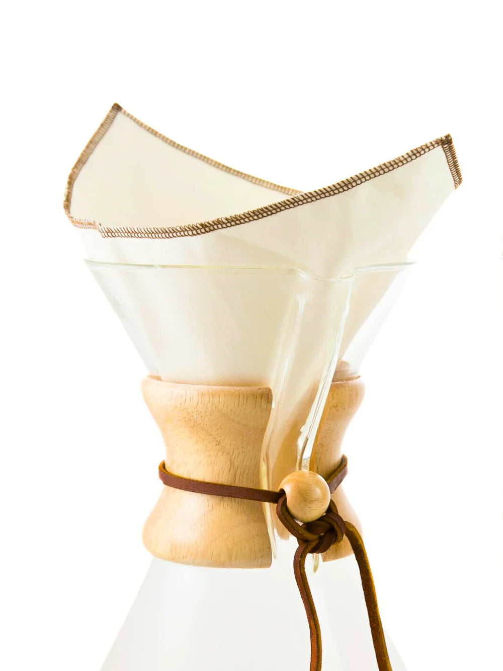 Clear glass coffee maker with wooden collar and fabric filter on a white background