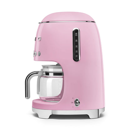 Pink coffee machine with clear glass carafe on a white background