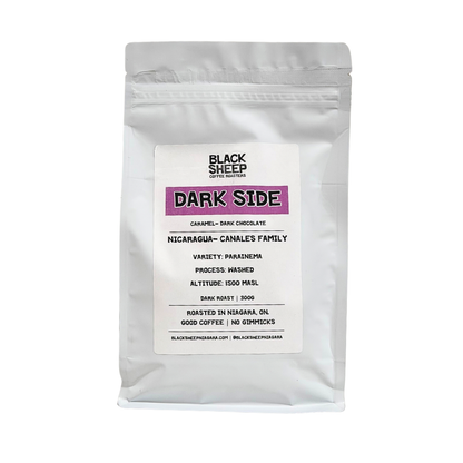 A white stand-up pouch of Black Sheep Coffee Roasters Dark Side coffee, featuring a white label with black text and a purple accent block, set against a plain white background.