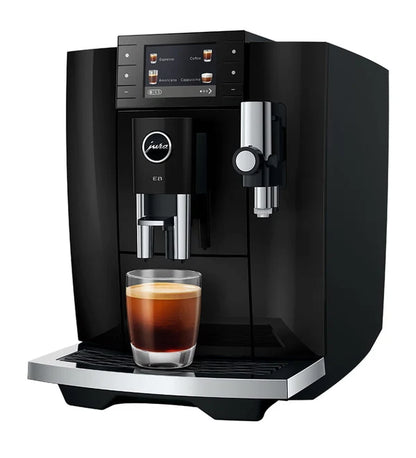 Black coffee machine with a glass of coffee on a white background