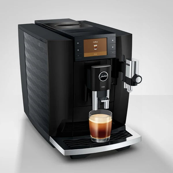 Black coffee machine with a glass of coffee on a white background
