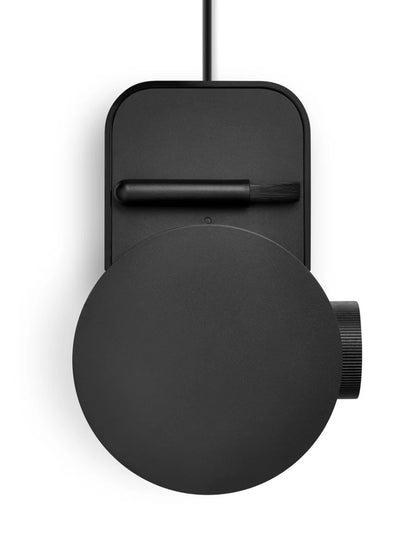 Top view of a black coffee grinder with round lid and rectangular stand on a white background