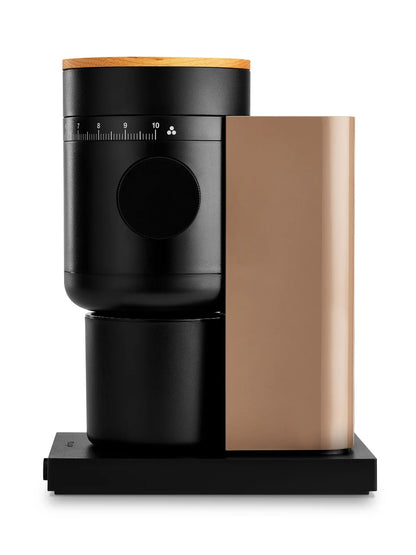 A modern coffee grinder with a matte black body, a vertical brushed malted chocolate colour side panel, and a light wood grain top, set against a solid white background.