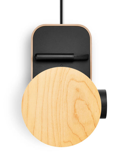 Wooden circular object with a black rectangular component on a white background