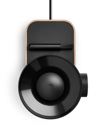 Black cylindrical device with a circular component on a white background