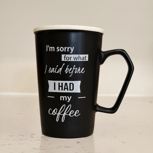 Black mug with white text on a light wooden surface