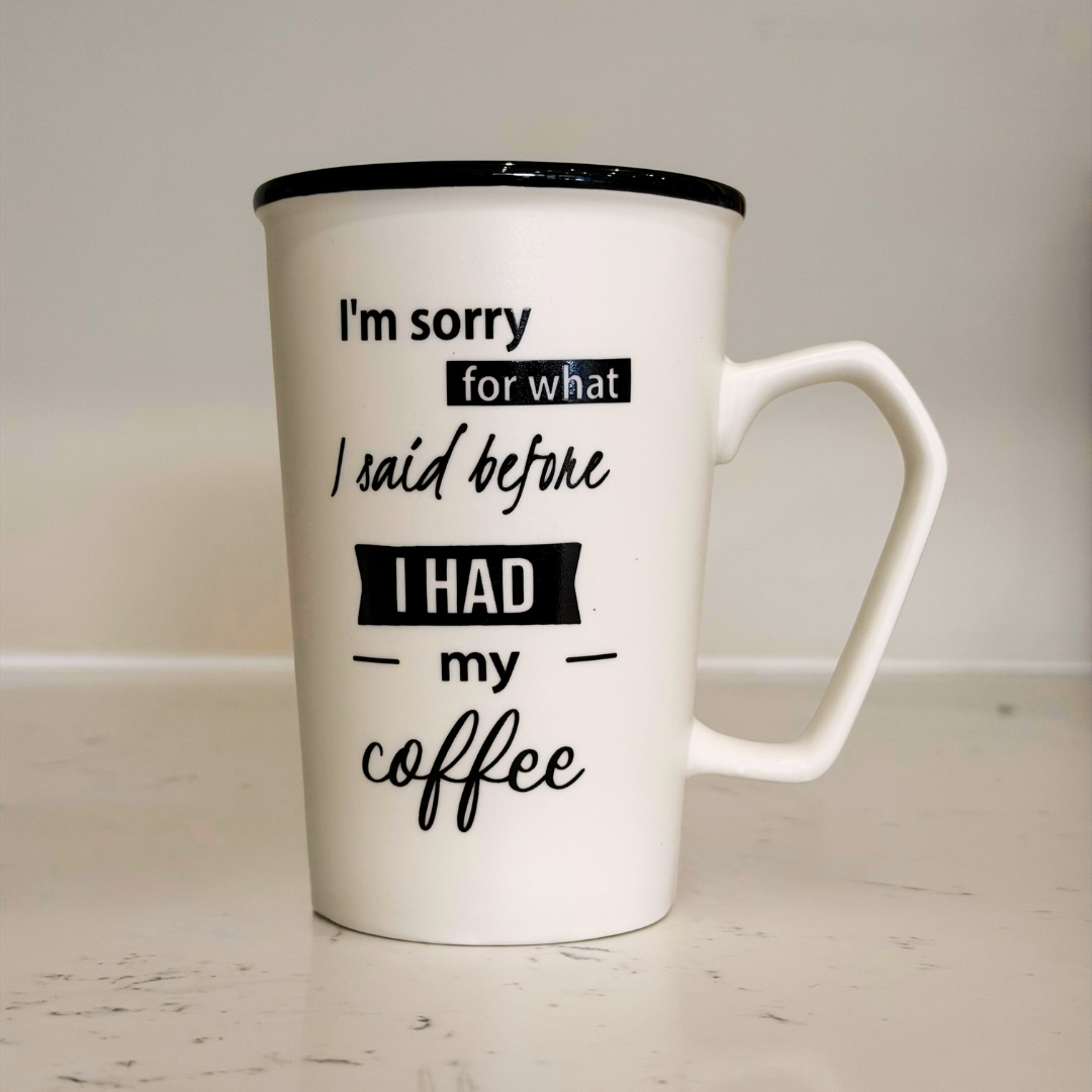 White mug with black text on a light wooden surface