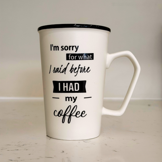 White mug with black text on a light wooden surface