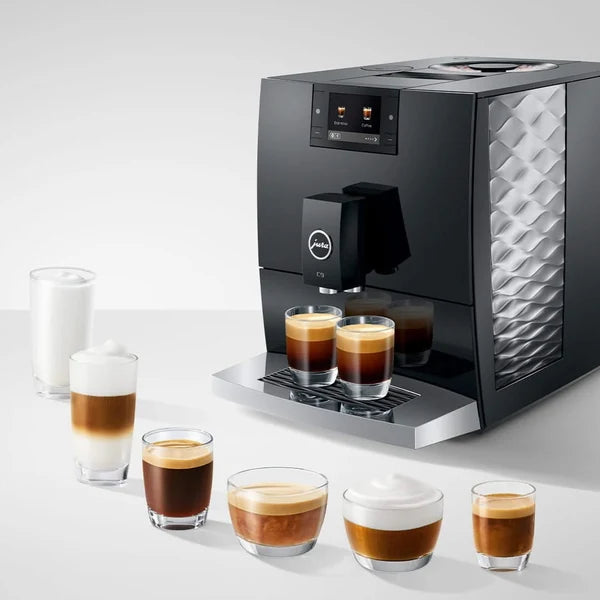 Jura coffee machine with various coffee beverages on a white surface