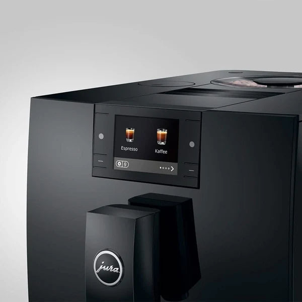 A close-up of a black Jura coffee machine showing its digital touch display screen with espresso and coffee icons, set against a clean light gray background.