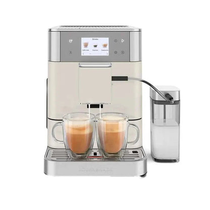 A light cream and stainless steel automatic espresso machine with two glass mugs of coffee on the drip tray and a transparent milk carafe to the right, shown on a white background.