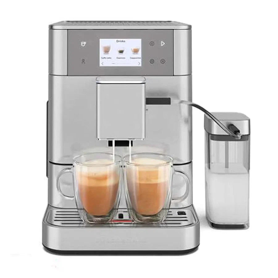 A silver espresso machine with two glass mugs filled with coffee and a clear milk container on a white background.