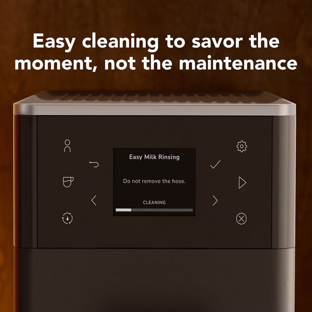 A close-up of a dark countertop appliance with a control panel and a small display reading 'Easy Milk Rinsing' and 'CLEANING.' Large white text above says 'Easy cleaning to savor the moment, not the maintenance.