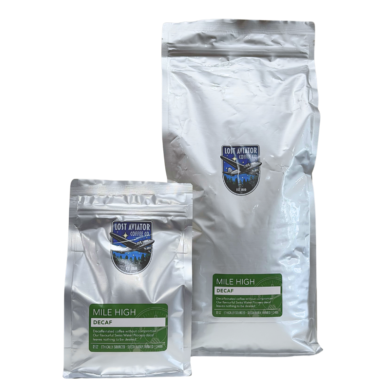 Two silver foil pouches of Lost Aviator Coffee Co. 'Mile High' Decaf coffee, one 340g and one 5lb, shown on a plain white background.