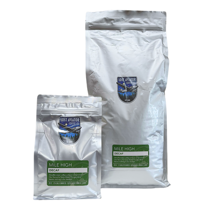 Two silver foil pouches of Lost Aviator Coffee Co. 'Mile High' Decaf coffee, one 340g and one 5lb, shown on a plain white background.