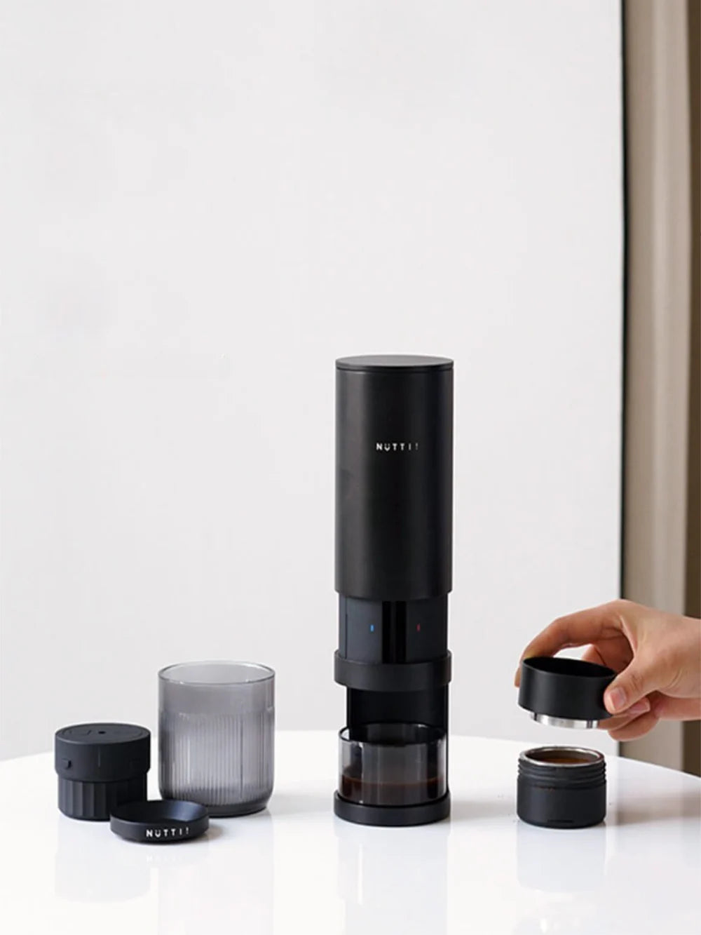 Black espresso machine with attachments on a white surface