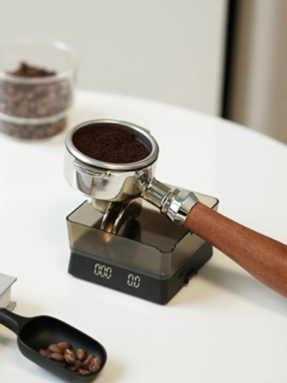 Espresso portafilter filled with ground coffee, resting on a digital scale,  on a white surface