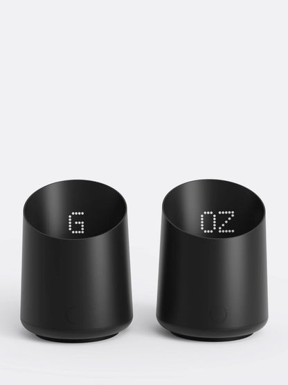 Two black digital coffee dosing cups on a white background