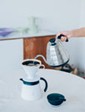 White electric kettle on a white surface with a blurred background