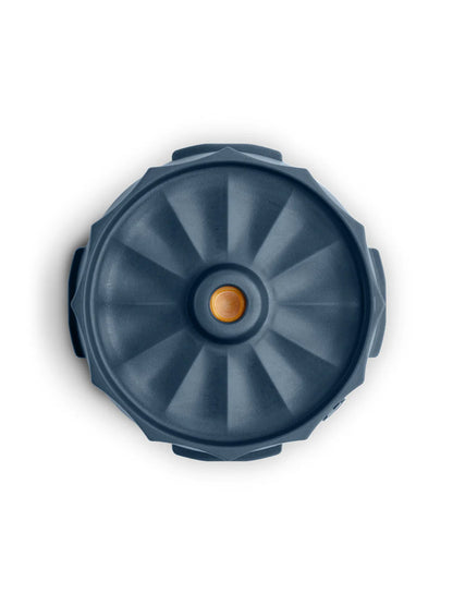 A top-down view of a dark slate blue circular lid with a textured radial pattern and a small orange accent in the center, set against a plain white background.