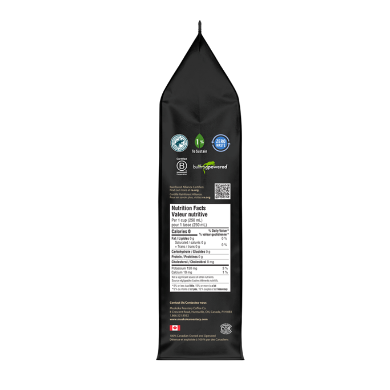 A black stand-up pouch of coffee beans shown from the back, featuring a white nutrition facts panel, certification logos, and the Green Powered brand name on a plain white background.