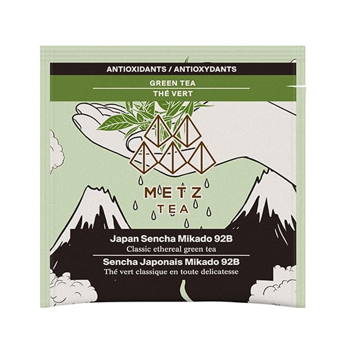Tea Bag with image of hand holding leaves with mountains in background