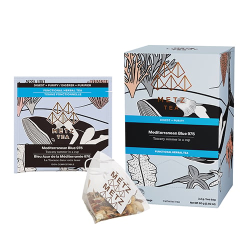 Box of Tea with a women laying on a whale surrounded by coral.